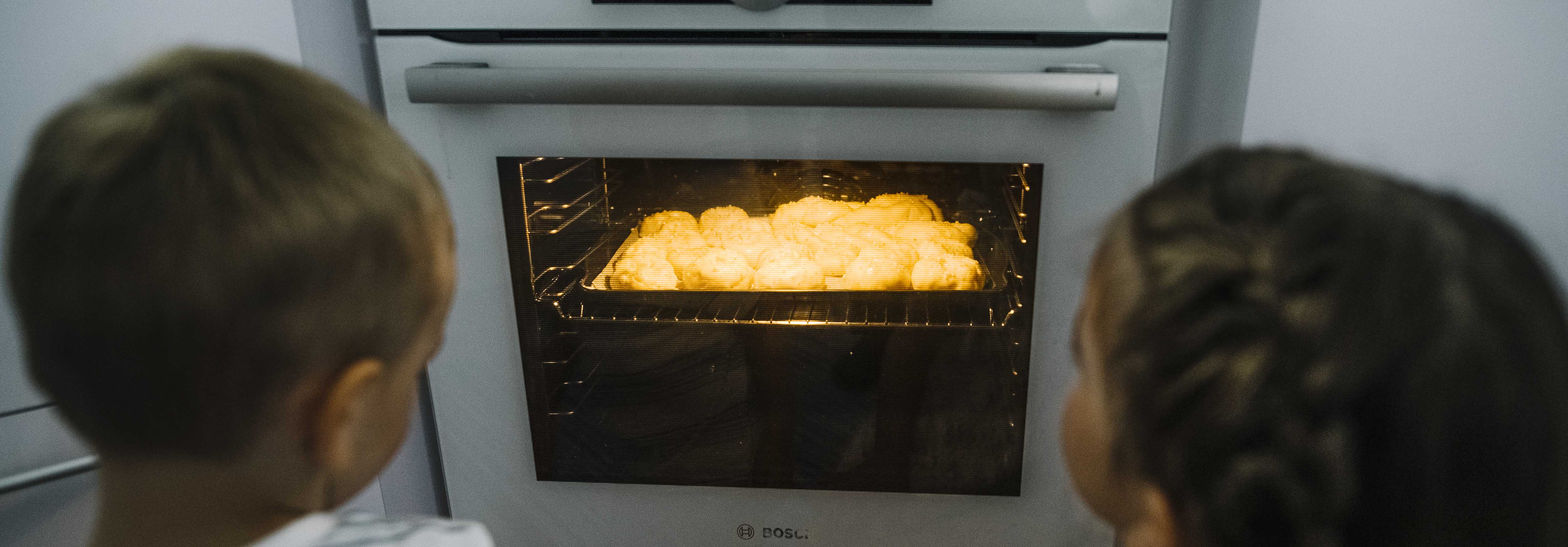 Lapset katsomassa uunissa paistuvia pullia