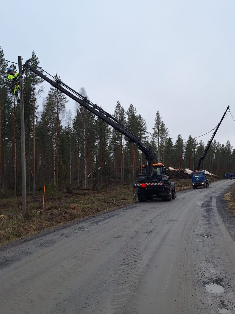 Nosturiauto ja asentaja ilmajohtoa siirtämässä