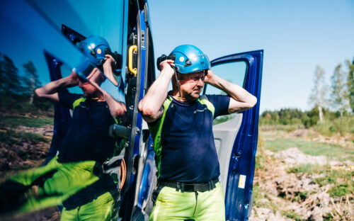 Asentaja laittamassa kypärää päähän